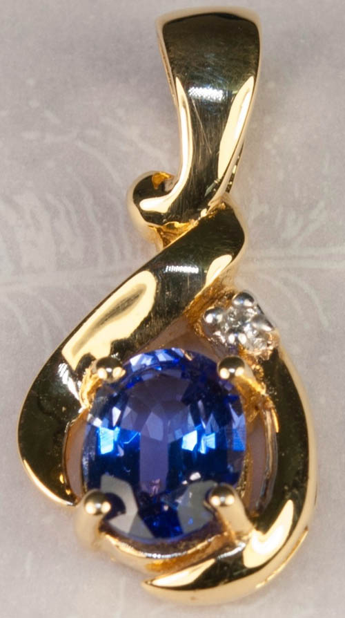 Enlarged closeup photo of the 14k yellow gold Tanzanite and diamond pendant. © Photography by, Lane & Margaret of Newport Ebay Solutions.